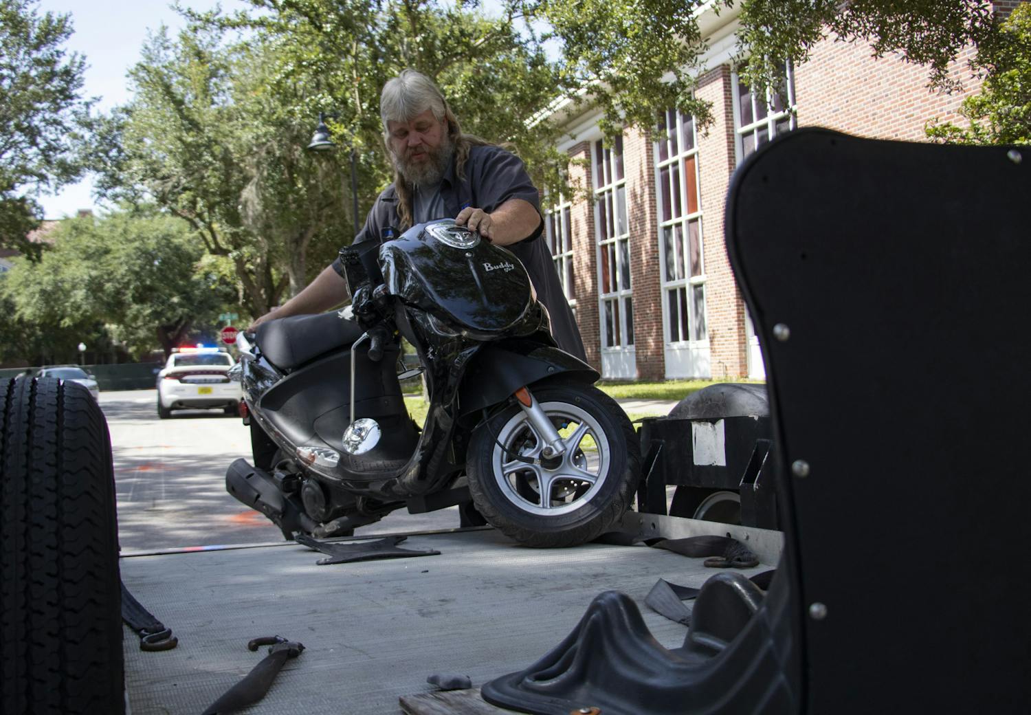 William Edwards, Elite Towing tow truck driver, puts the scooter involved in the crash on Northwest 16th Street on his trailer on Monday, Aug. 30, 2021. 