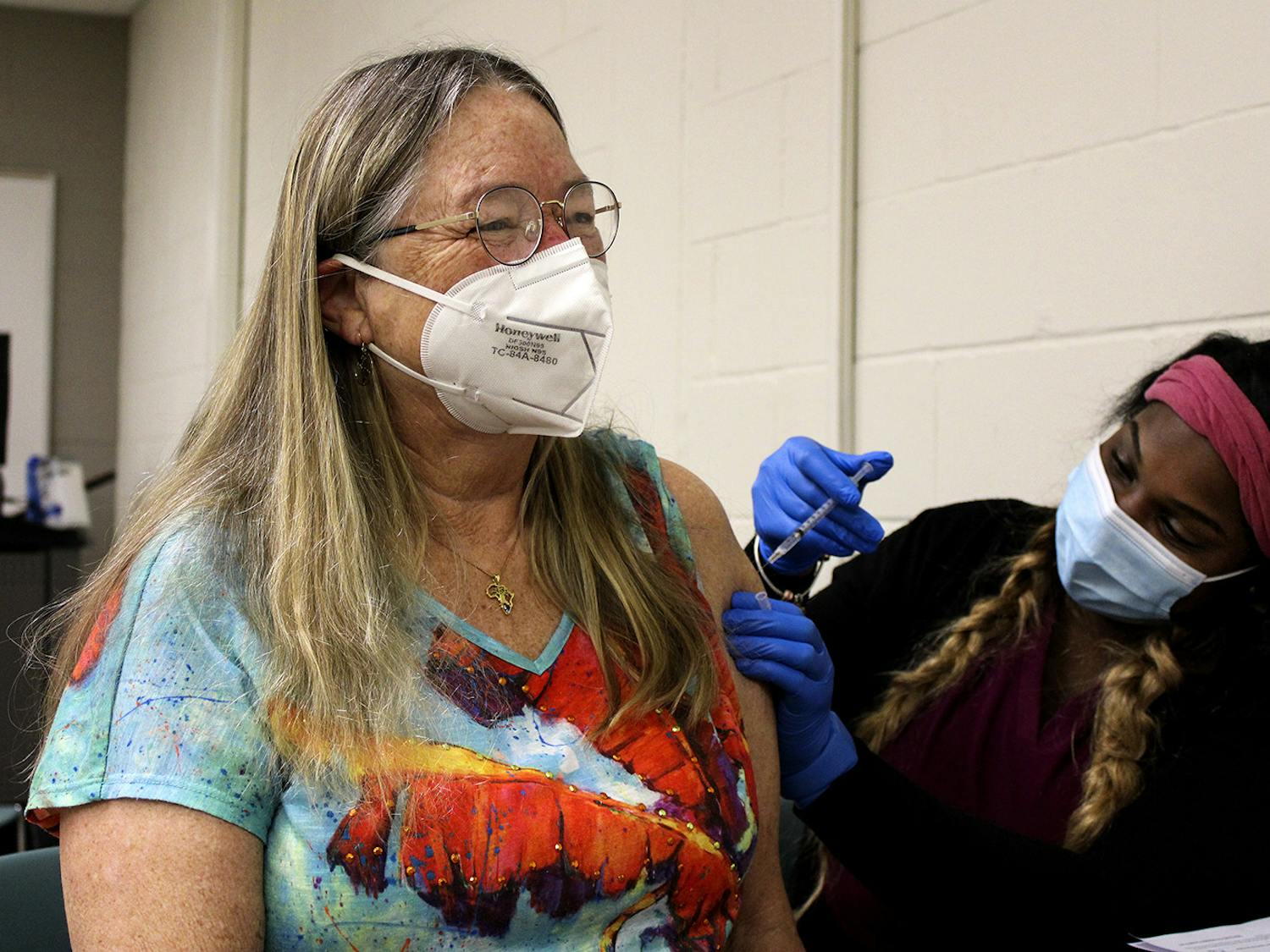 Janée Gilliam, a nurse for the Alachua County Department of Health, injects Linda Tyson, 65, a Sante Fe biology professor, with the Pfizer-BioNTech COVID-19 vaccine Friday, Feb. 26, 2021 at Santa Fe College. “The college has done us a great service,” Tyson said about the vaccine distributions.