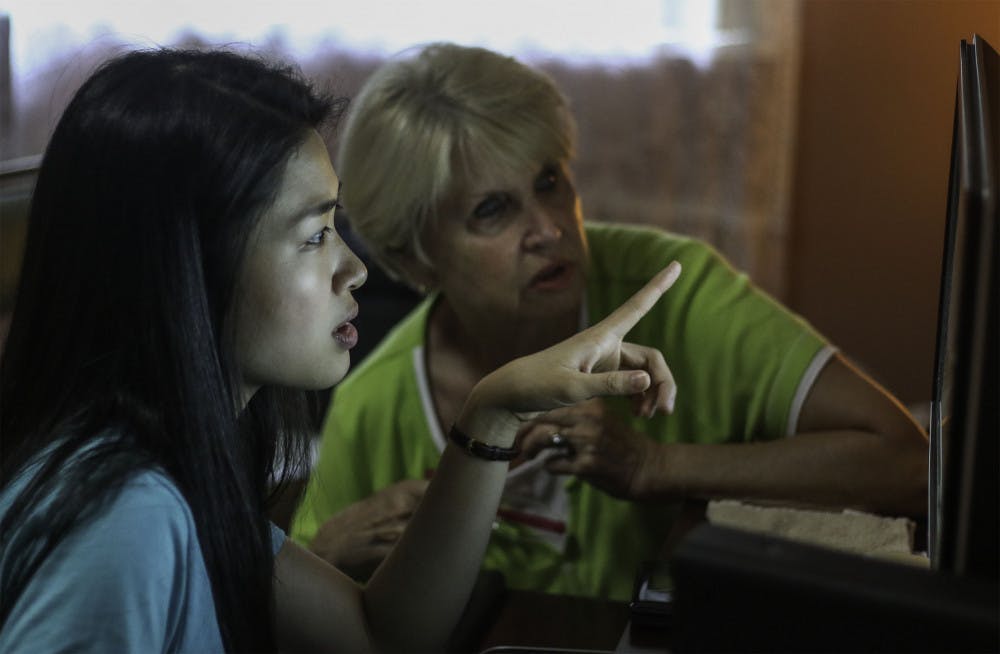 Ming Yang, the 24-year-old CEO and founder of Orchard, shows B.J. Summerlin, a 76-year-old retired nurse, how Yang fixed her computer from turning on by itself in the evenings. Summerlin said the company brings a great value because she feels comfortable with them coming into her home and patiently teaching her. “I feel like I’ve rented a grandchild,” Summerlin said.  