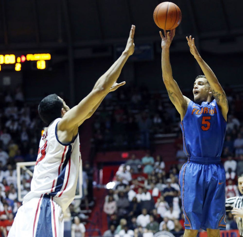 <p>Scottie Wilbekin (5) attempts a shot as Ole Miss forward Anthony Perez (13) tries to block during Florida’s 75-71 win in Oxford, Miss., on Saturday. Wilbekin scored a team-high 18 points against the Rebels.</p>
