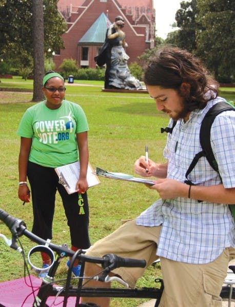 Janine Monfries, 21, helps with the Power Vote campaign while Alec Shoelson, 22, fills out a Power Vote pledge card on Thursday.