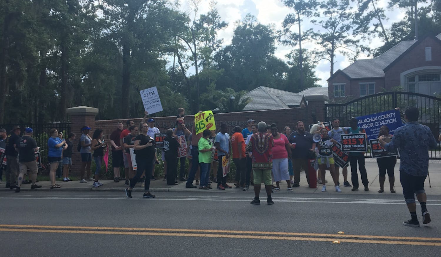 Protestors rally in front of the Earl and Christy Powell University House.