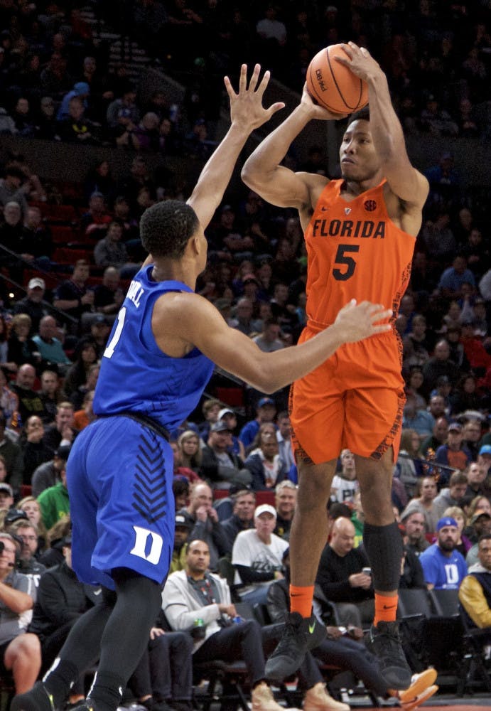 Florida guard KeVaughn Allen, right, shoots over Duke guard Trevon Duval during the first half of an NCAA college basketball game in the Phil Knight Invitational tournament in Portland, Ore., Sunday, Nov. 26, 2017. (AP Photo/Craig Mitchelldyer)