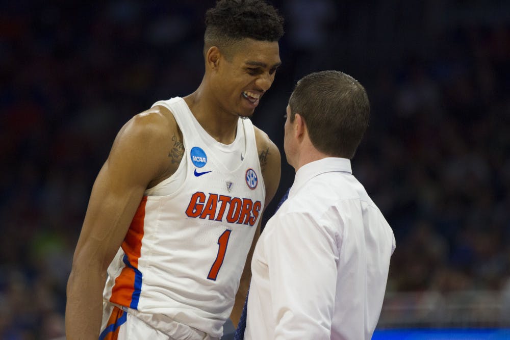 <p>Devin Robinson smiles with UF coach Mike White in Florida's 65-39 win over Virginia in the Round of 32 in the NCAA Tournament on Saturday in Orlando. </p>