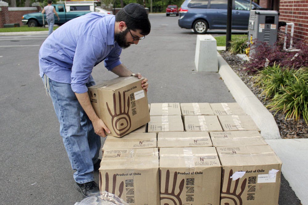 David Portnow, a 22-year-old UF neuroscience senior, unloads boxes of supplies at the Jewish Center at 2021 NW Fifth Ave. in preparation for the Passover seder. He said some food and drinks have to be specially ordered due to dietary restrictions for Passover.