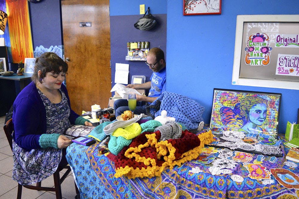 Caitlin Hare (left) displays her original artwork consisting of stuffed toys, stickers and clothes at the Midnight's Big Fat Rummage Sale on Saturday.