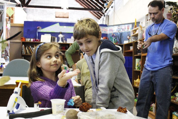 Second-graders Claire Rotchford and Bryce Beckett create shadow boxes with garbage they collected from Littlewood Elementary School and other items at the Repurpose Project on Saturday.