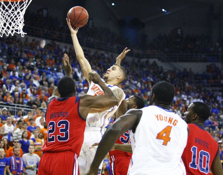 Florida guard Scottie Wilbekin attempts a shot against Ole Miss forward Reginald Buckner during the Gators’ 78-64 win against the Rebels on Saturday at the O’Connell Center.