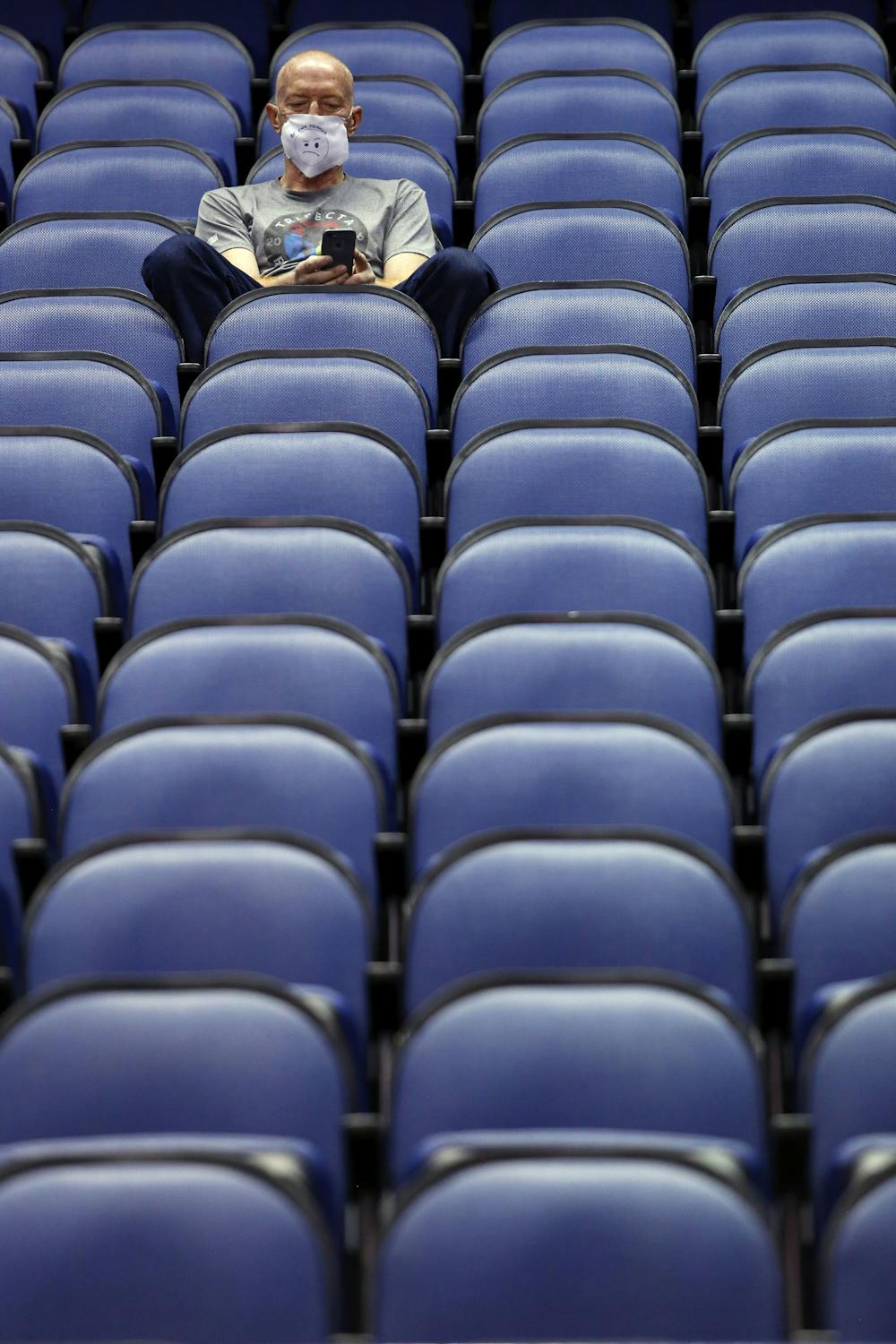 <p>Mike Lemcke, from Richmond, Va., sits in an empty Greensboro Coliseum after the NCAA college basketball games were cancelled at the Atlantic Coast Conference tournament in Greensboro, N.C., Thursday, March 12, 2020. The biggest conferences in college sports all canceled their basketball tournaments because of the new coronavirus, seemingly putting the NCAA Tournament in doubt. (AP Photo/Ben McKeown)</p>
