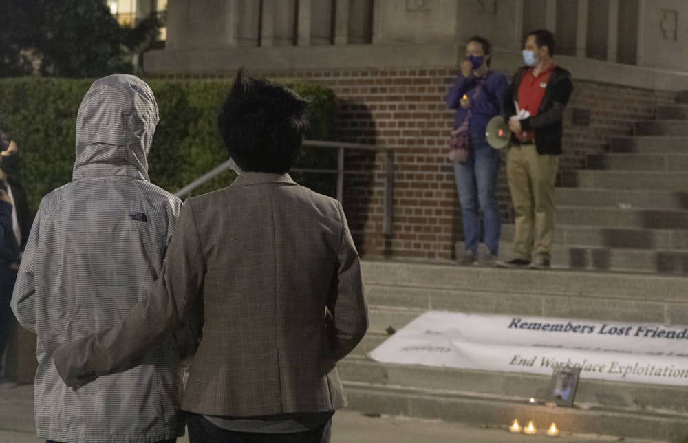 Two attendees stand in front of Tigert Hall at UF during a vigil on Thursday, April 1 honoring the life of international graduate student Huixiang Chen, who died by suicide in 2019. UF's Graduate Assistants United organized the event to express frustrations over abusive graduate student-mentor relationships.