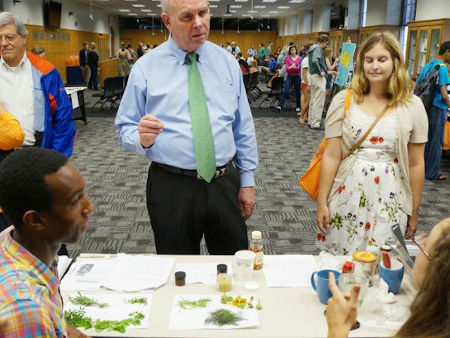 UF President Bernie Machen learns about teas from UF seniors Kamal Gray, 21, and Brielle Martinez, 21, before delivering his State of Sustainability address at Sustainable UF’s Campus Earth Day Celebration on Friday.