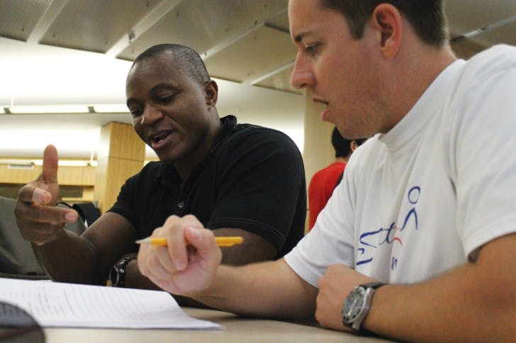 Dave Pittman, right, 35, is tutored by Tshi Tshi Kalala, 38, in Swahili. Pittman is a second-year sustainable development practice graduate student, and Tshi Tshi Kalala is a tutor for the University Athletic Association.