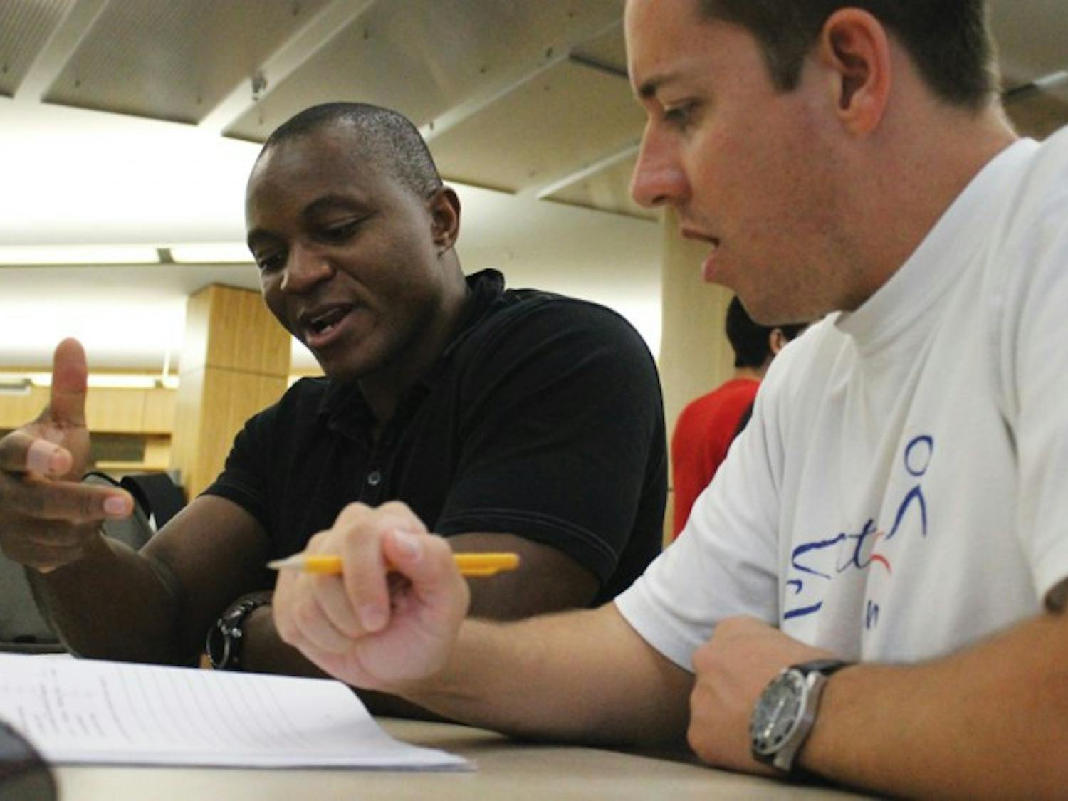 Dave Pittman, right, 35, is tutored by Tshi Tshi Kalala, 38, in Swahili. Pittman is a second-year sustainable development practice graduate student, and Tshi Tshi Kalala is a tutor for the University Athletic Association.