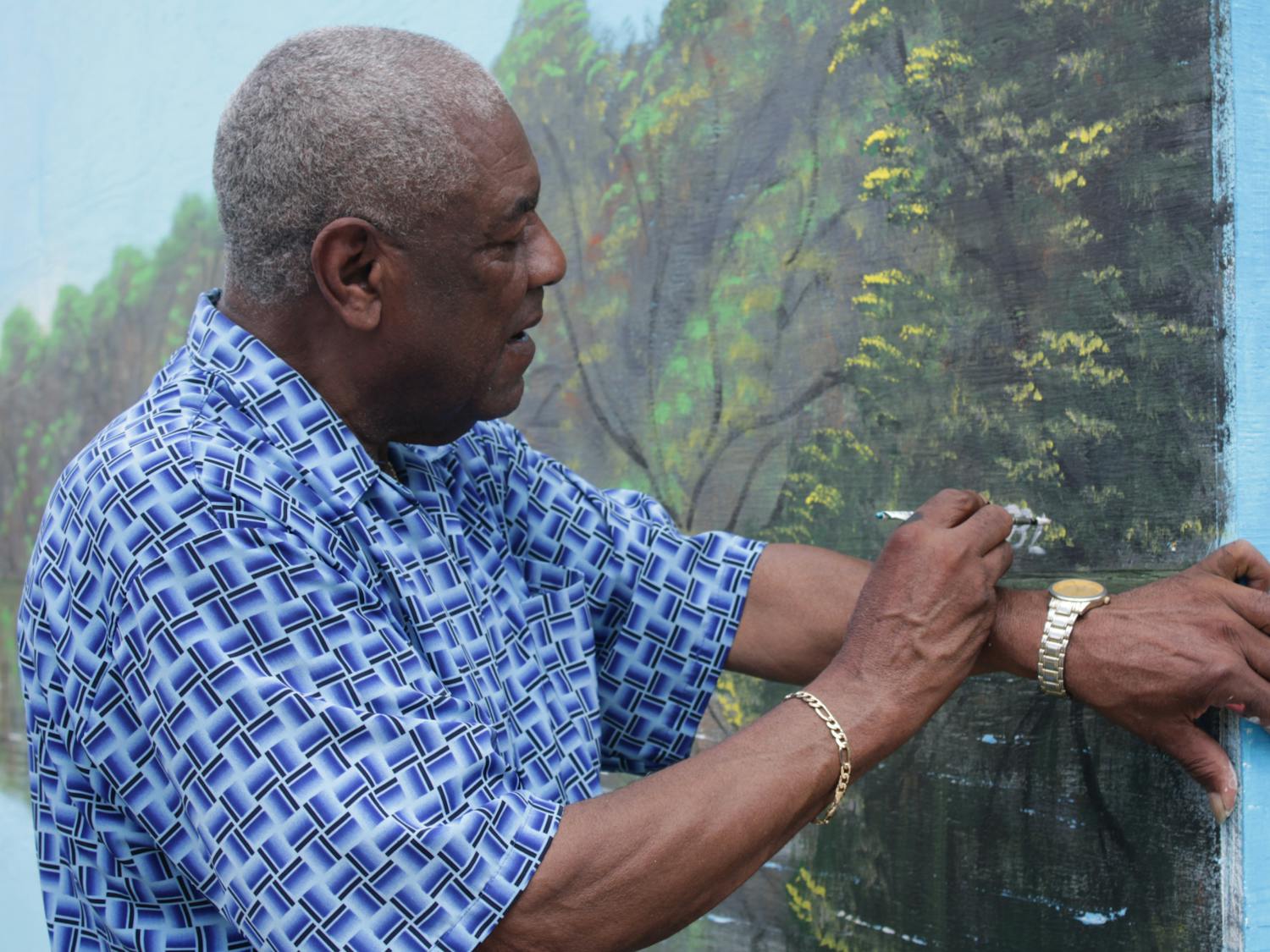 Al Black signs his name as the finishing touch on the Highwaymen mural Wednesday, Aug. 23, 2022.