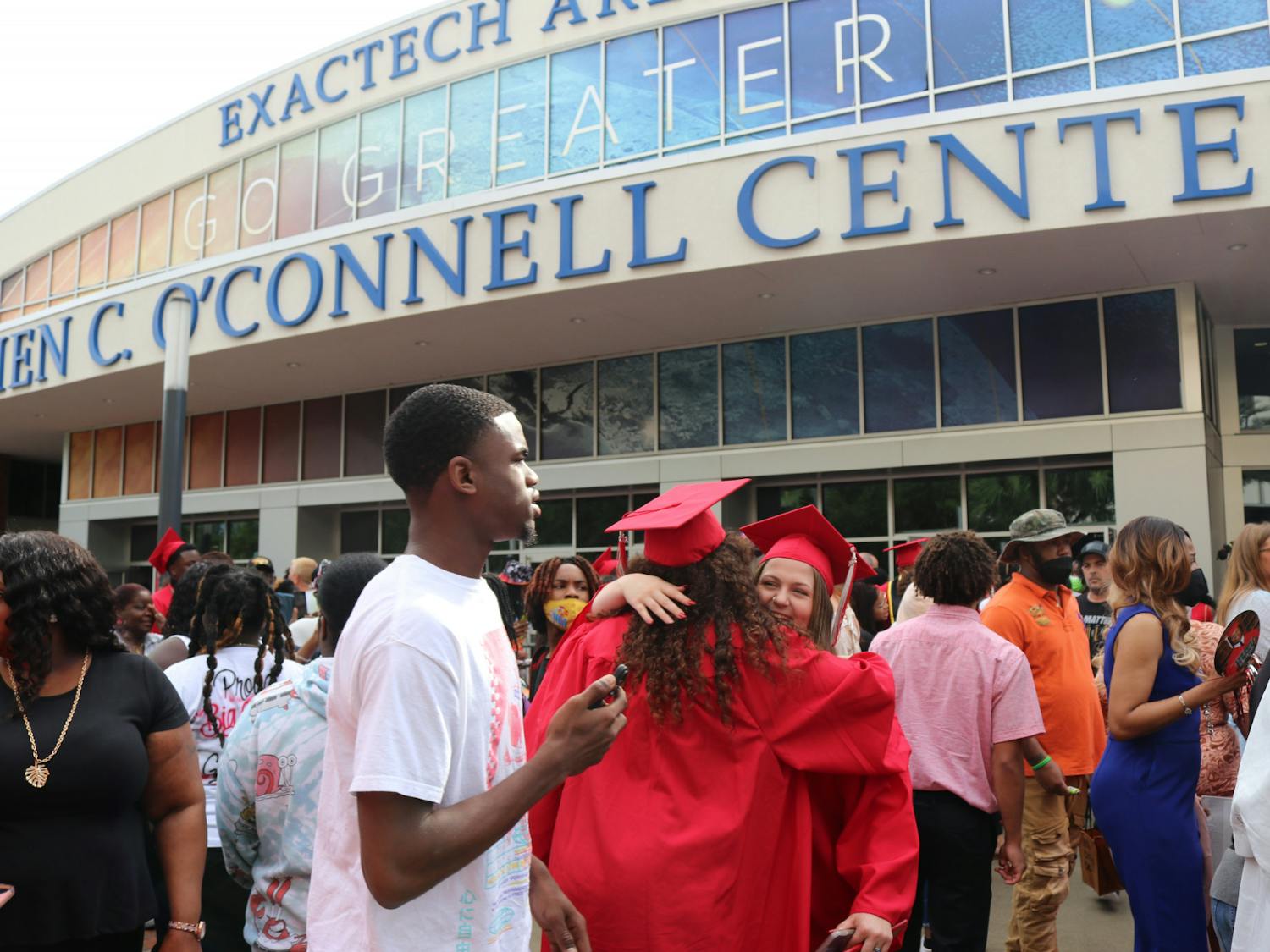 Two graduates congratulate each other outside of the O’Connell Center after the Sante Fe High School Commencement Ceremony on May 27, 2022. 