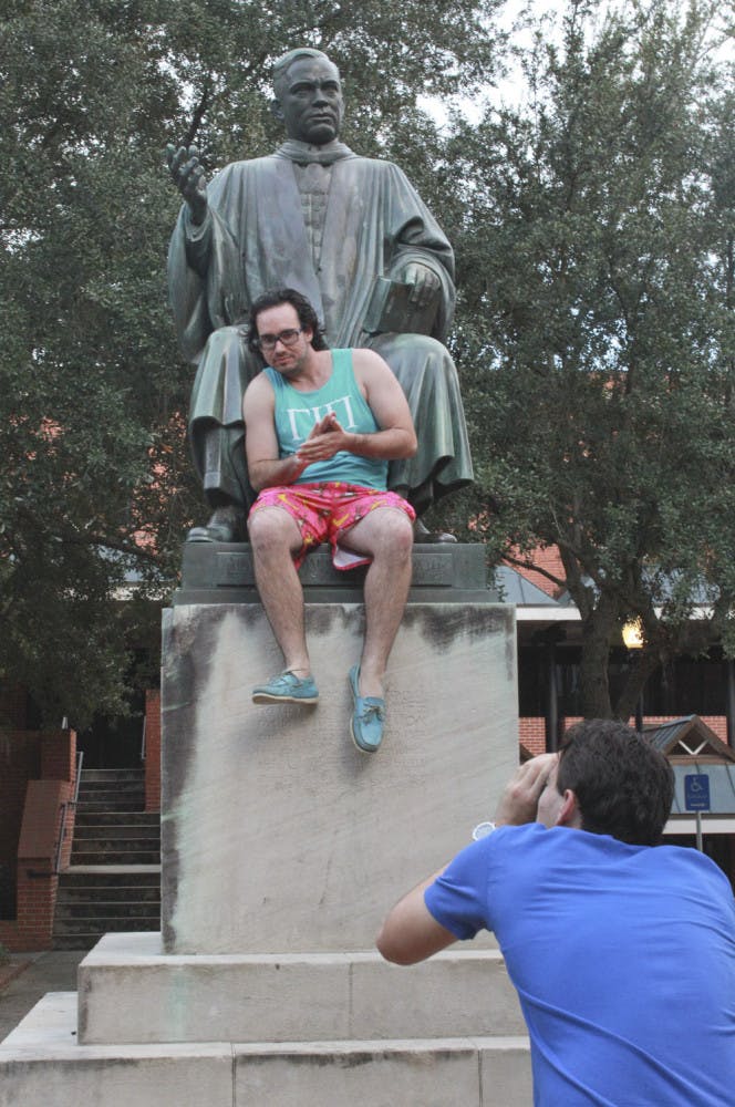 Griffin Plattner, a 22-year-old UF chemical engineering and business management senior, climbs onto the statue of Albert A. Murphree outside Criser Hall during the Senior Bucket List Tour. “This has been, by far, one of my funnest semesters,” said Plattner, who graduates this semester.