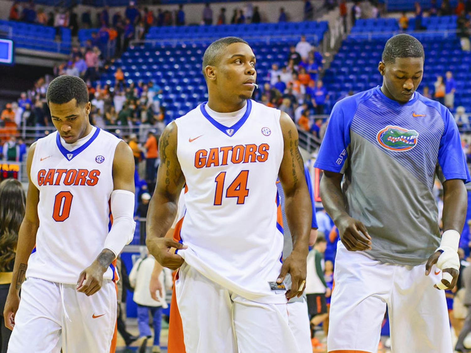 Kasey Hill (left), Lexx Edwards and Dorian Finney-Smith walk off the O'Connell Center floor following Florida's 69-67 loss to Miami on Monday.