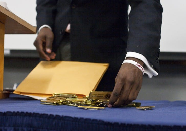 Senate President Aundre Price sorts through new name tags for the senators at Tuesday night's meeting.