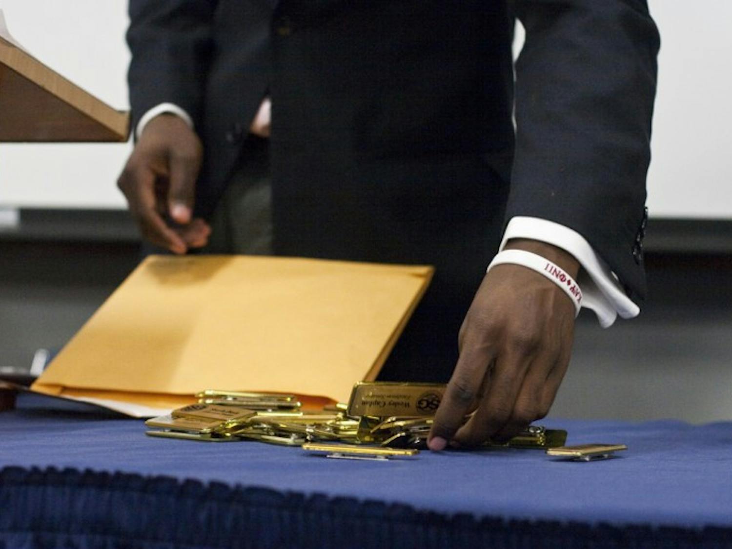Senate President Aundre Price sorts through new name tags for the senators at Tuesday night's meeting.