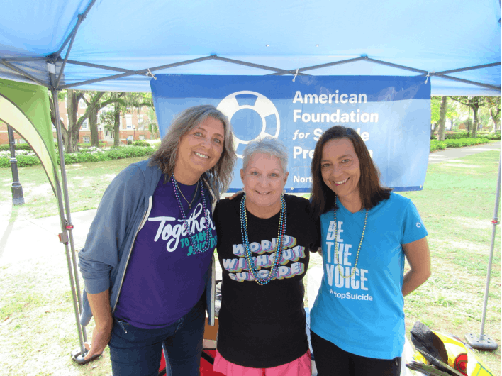 Candi Morris, center, embraces her good friends Carol Guggenheimer, left, and Wendy Thompson, right, at the American Foundation for Suicide Prevention’s campus walk last spring. Photo courtesy of Rachel Wimer. 