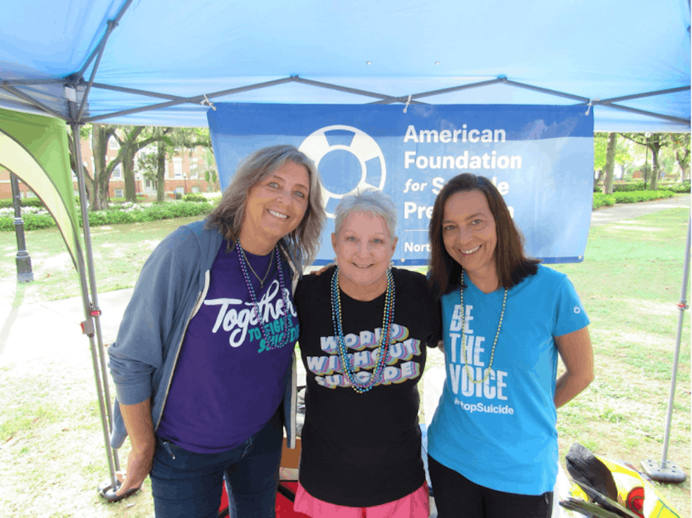 <p>Candi Morris, center, embraces her good friends Carol Guggenheimer, left, and Wendy Thompson, right, at the American Foundation for Suicide Prevention’s campus walk last spring. Photo courtesy of Rachel Wimer. </p>