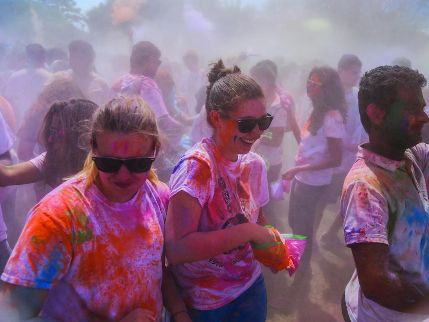 A group of students laugh as more than 1,000 people throw paint during the UF Holi Festival of Colors on Sunday. 