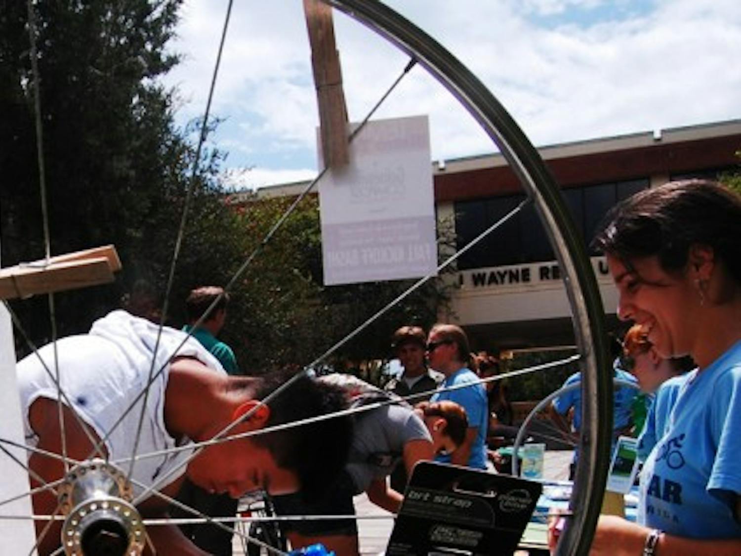 Steven Che, food science and human nutrition freshman, 19, signs up for a raffle to win a free bike light from Bicycle Benefits at the Alternative Transportation Fair in front of the Reitz Union Colonnade on Wednesday. Bicycle Benefits is a program that offers a $5 helmet decal for discounts at select local businesses.