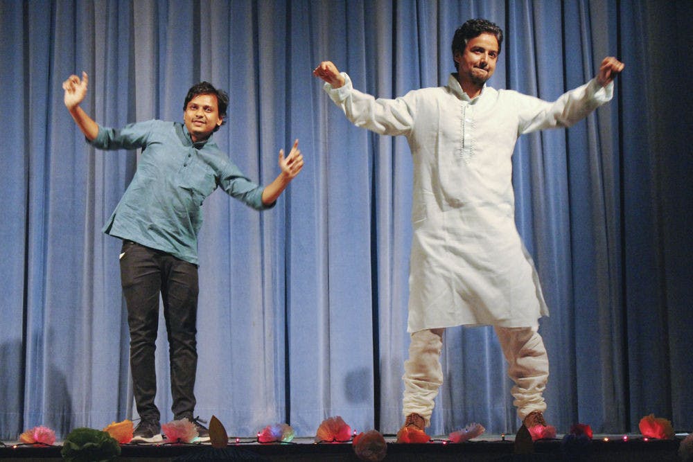 <p>Biswas Rijal, right, a UF materials science graduate student, was cajoled into doing a traditional dance from North India called bhangra in front of about 600 people celebrating Diwali at the India Cultural and Education Center on Nov. 14, 2015. He pulled his friend, Gaurav Sultania, left, a UF civil engineering graduate student, onstage with him so he wouldn't have to perform alone.</p>
