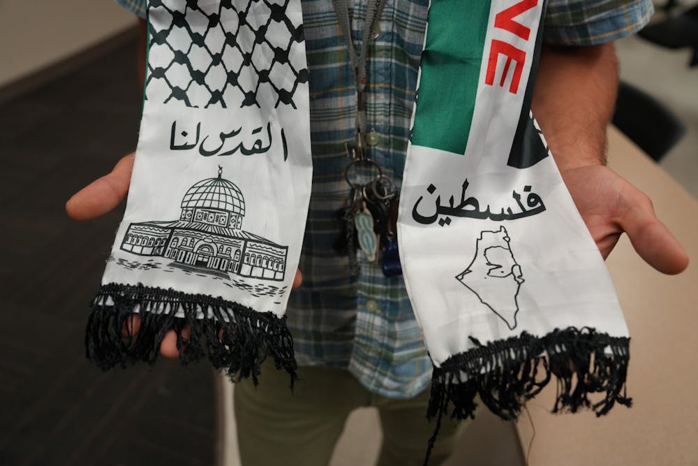 <p>Majd Afaghani, attends UF SJP’s discussion in Turlington wearing a Palestine kufiyyeh neck scarf on Thursday Oct. 12, 2023.</p>