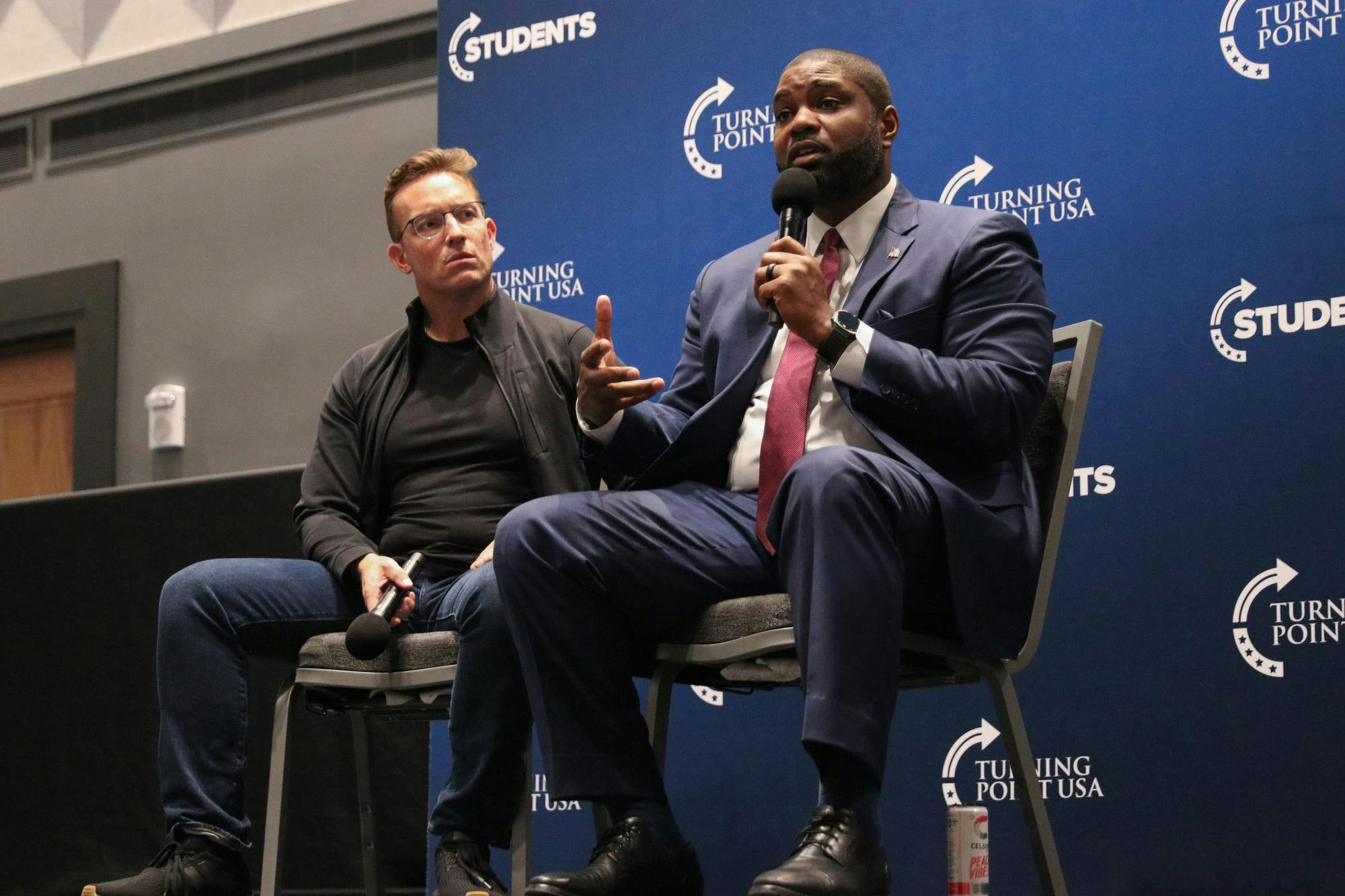 Conservative political commentator Benny Johnson listens as U.S. representative Byron Donalds speaks at the Leading the Next Generation event sponsored by the University of Florida Turning Point USA chapter at the Reitz Union Ballroom Thursday, Nov. 13, 2025.