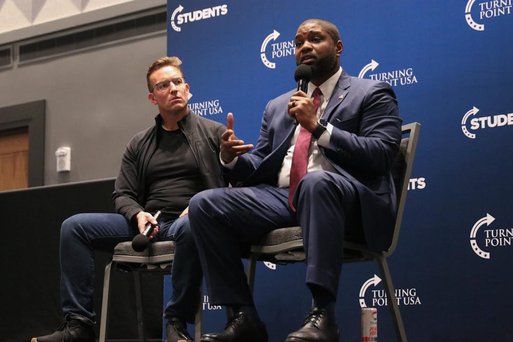 Conservative political commentator Benny Johnson listens as U.S. representative Byron Donalds speaks at the Leading the Next Generation event sponsored by the University of Florida Turning Point USA chapter at the Reitz Union Ballroom Thursday, Nov. 13, 2025.