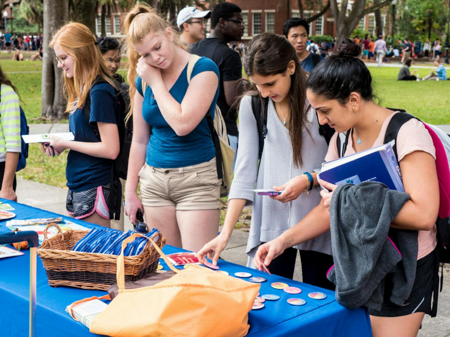UF health education senior Tala Rizkallah, 21, and UF communication sciences and disorders senior Michelle Saade, 21, check out health-oriented pins at the GatorWell table at the Freshman 15 Wellness Fair on the Plaza of the Americas on Wednesday afternoon.