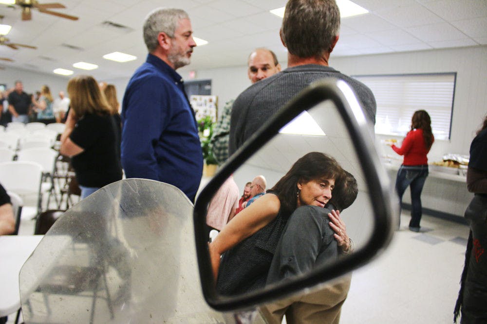 Marion Rose Harvey's sister, Evelyn, embraces Harvey's son-in-law Troy Anderson during her sister's memorial service in Fort White on Friday.