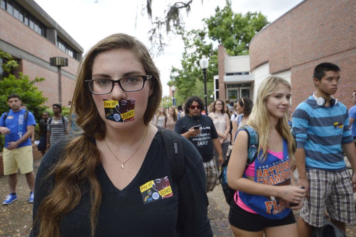 Kerry Stern, a 21-year-old UF economics major, stands in silence with her peers as part of the Day of Silence in support of LGBTQ students on Turlington Plaza on Friday afternoon.