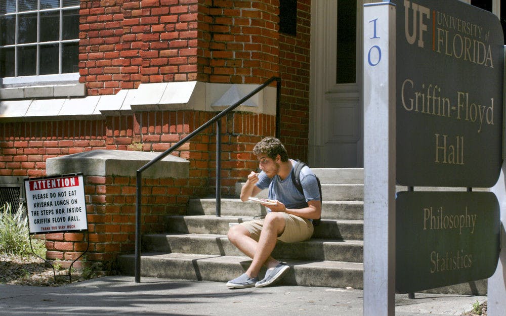 <p>Brian David Schwartz, a UF telecommunications sophomore, chows down on Krishna lunch on the steps of Griffin-Floyd Hall on Sept. 3. Students are banned from eating on the stairs to prepare for extra seating renovations. “Having Krishna lunch is a very communal experience,” Schwartz said, “us all eating the same food to the beat of a drum.”</p>