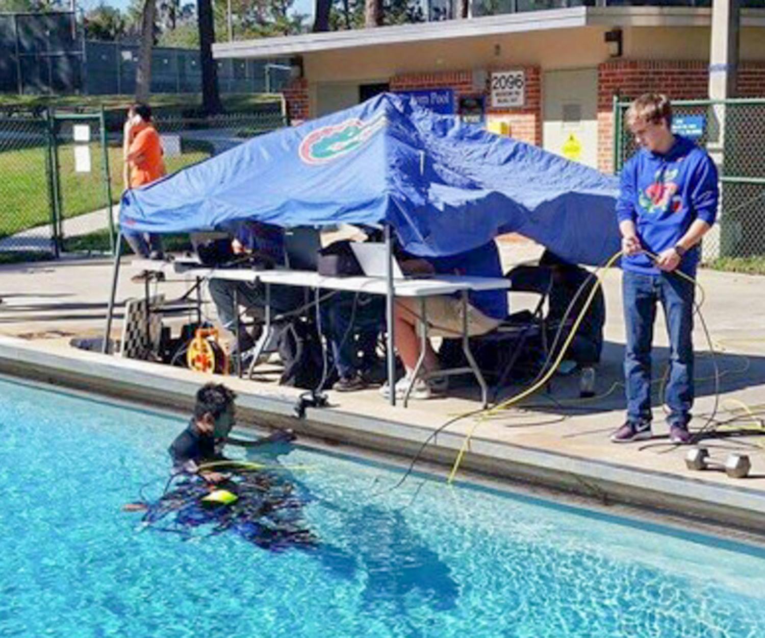 Members of Project GATOR test their “subjugator” underwater robot in a pool by Graham Hall. The group received a $6,000 grant from the U.S. Department of State to help build the machine, which searches for abandoned crab fishing traps.