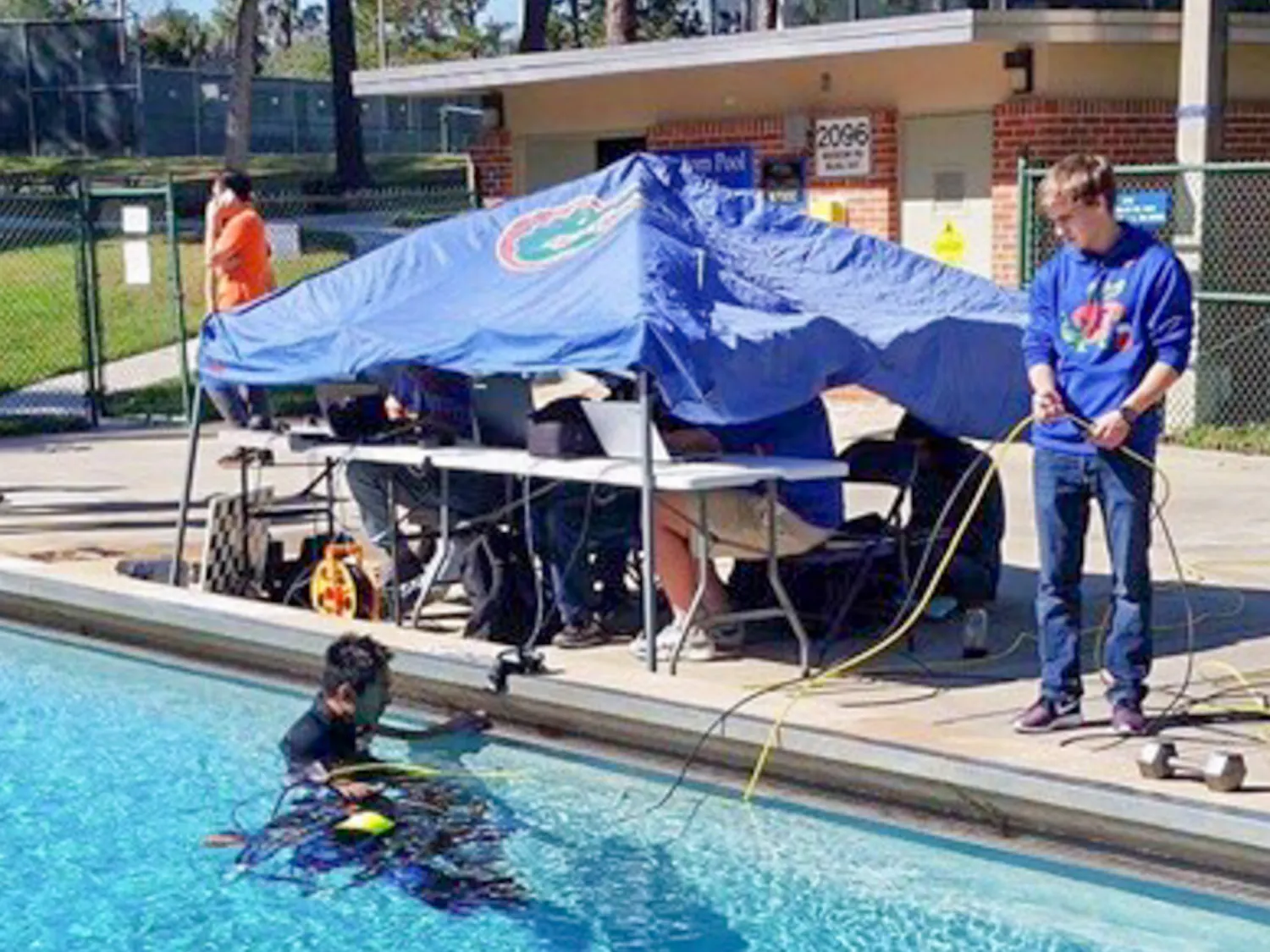 Members of Project GATOR test their “subjugator” underwater robot in a pool by Graham Hall. The group received a $6,000 grant from the U.S. Department of State to help build the machine, which searches for abandoned crab fishing traps.