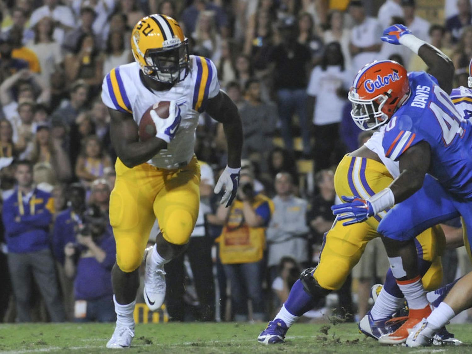 LSU running back Leonard Fournette carries the ball as he's chased by UF linebacker Jarrad Davis (40) during the Tigers' 35-28 win against the Gators on Oct. 17, 2015, at Tiger Stadium in Baton Rouge, Louisiana.