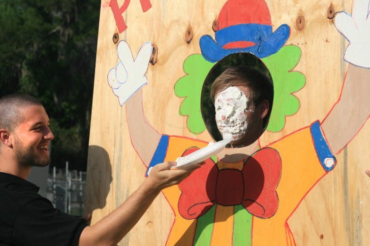 Brandon Corsentino, a 20-year-old marketing sophomore, pies Garrett Chappell, a 20-year-old advertising junior, at the Dance Marathon kickoff event on Flavet Field on Thursday.