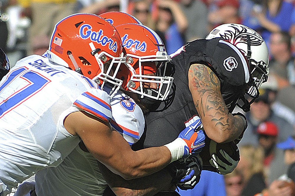 UF defensive end Jordan Sherit and linebacker Antonio Morrison record a tackle during Florida's 24-14 win against South Carolina on Nov. 14, 2015, at Williams-Brice Stadium in Columbia, South Carolina.
