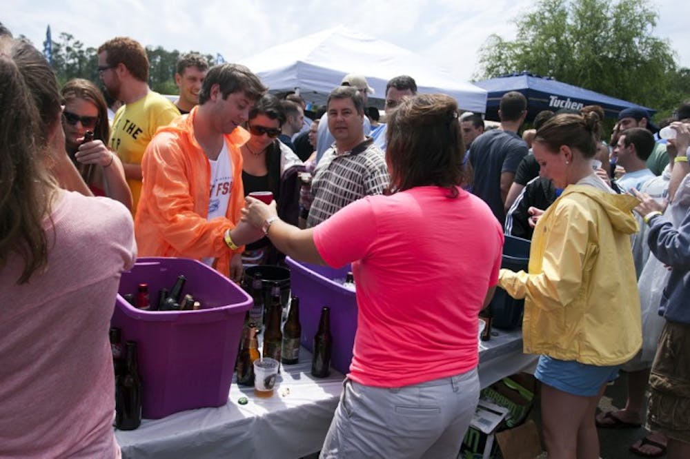 <p>Wendell Stainsby, a 22-year-old environmental engineering major, picks up a craft beer from 22-year-old marketing major, Chelsea Schaffer, at the Greater Gator Beer Festival on Saturday.</p>