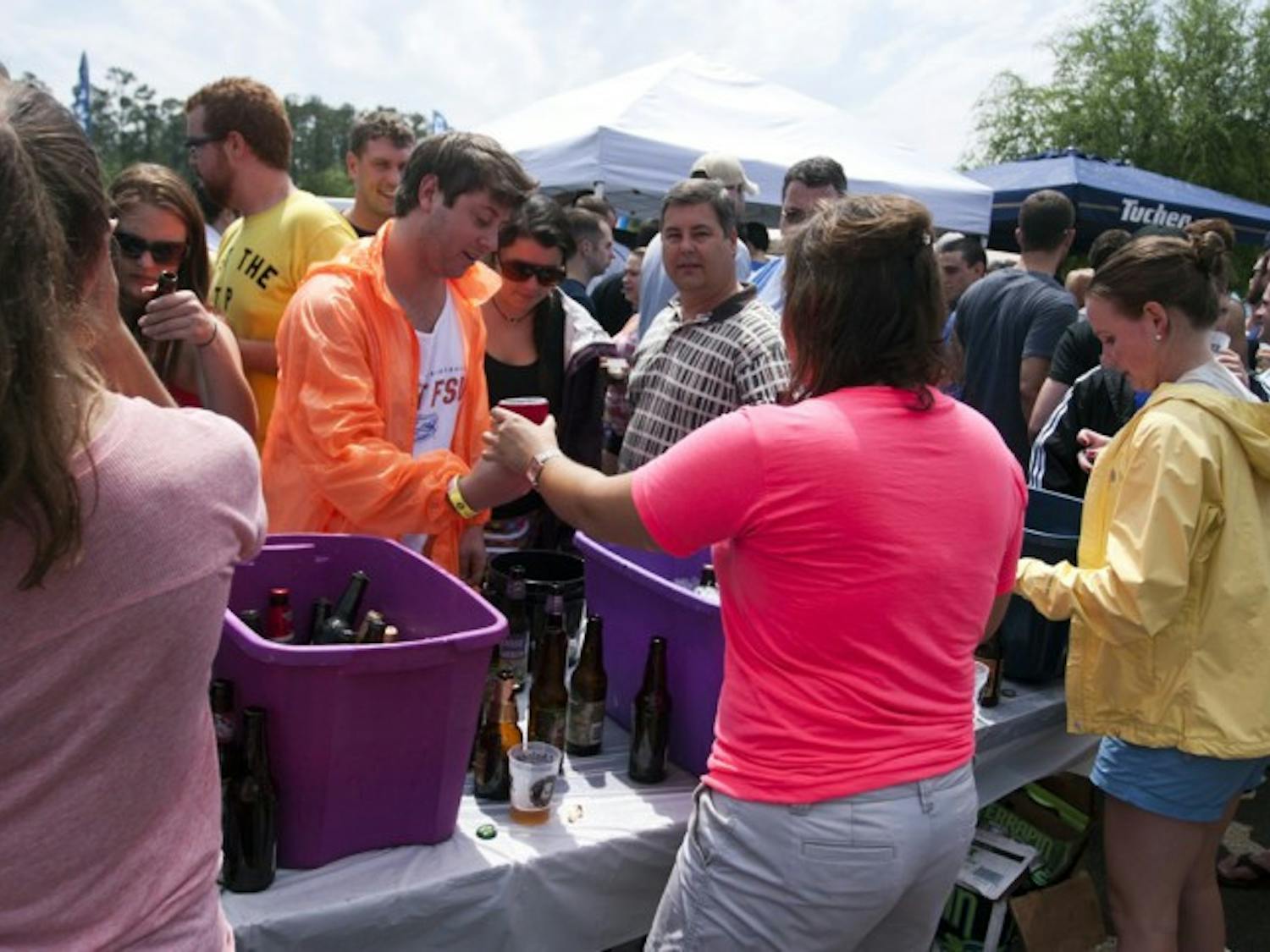 Wendell Stainsby, a 22-year-old environmental engineering major, picks up a craft beer from 22-year-old marketing major, Chelsea Schaffer, at the Greater Gator Beer Festival on Saturday.