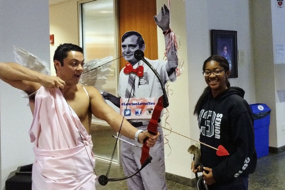 <p>Bobby Walsh (left), a 25-year-old UF law student, poses for a picture while dressed as Cupid at the Lawton Chiles Legal Information Center open house in the Law library Thursday.</p>