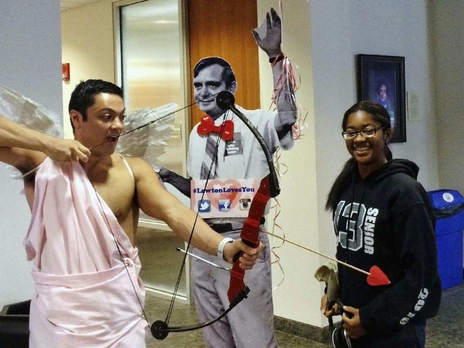Bobby Walsh (left), a 25-year-old UF law student, poses for a picture while dressed as Cupid at the Lawton Chiles Legal Information Center open house in the Law library Thursday.