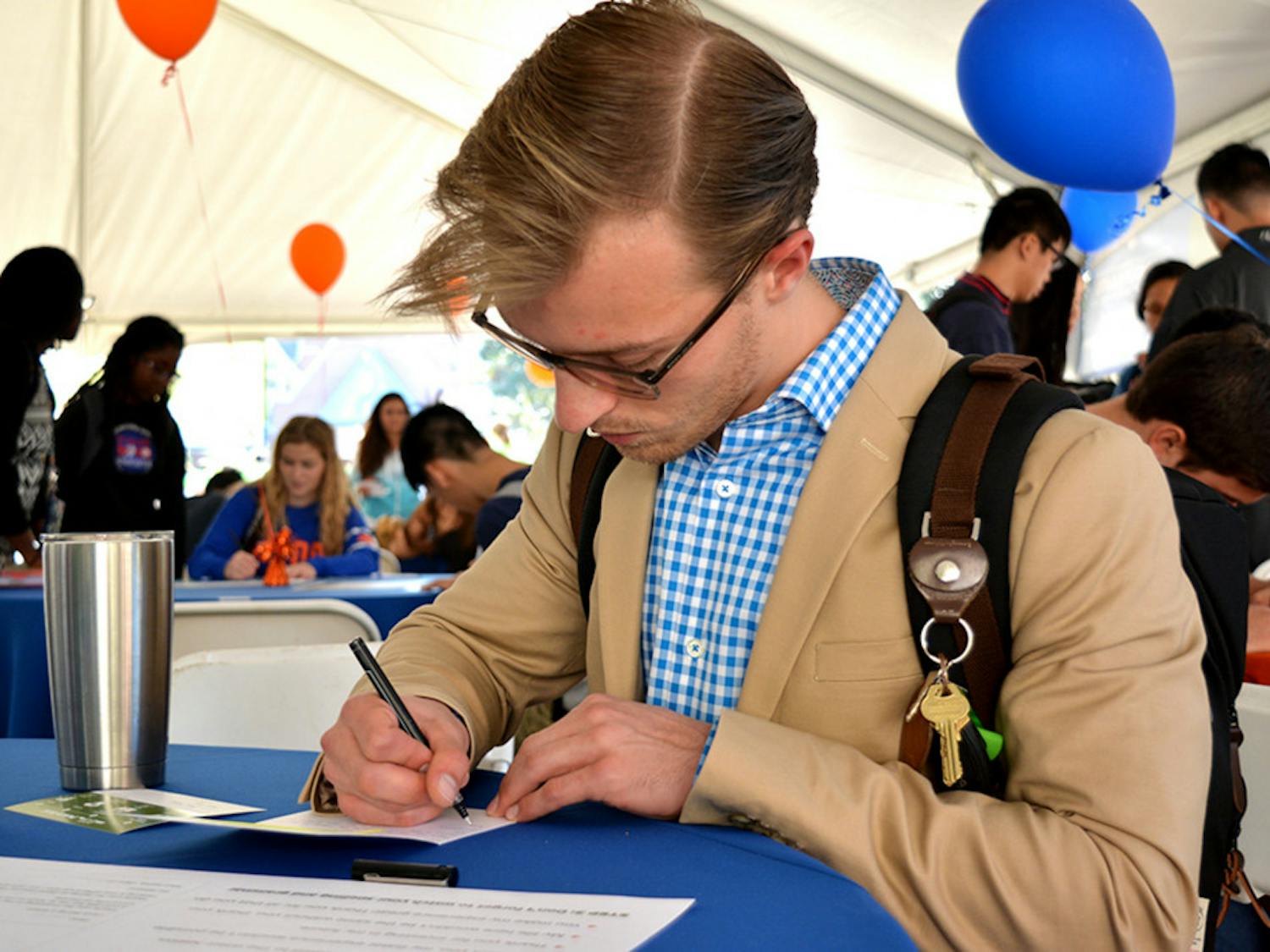 Jake Hughes, a UF chemical engineering junior, writes a letter at Grateful Gator Day. “It’s a cool idea,” he said. Hughes’ letter, addressed to Mr. and Mrs. Williams, was one of more than 2,000 that will be sent to donors.