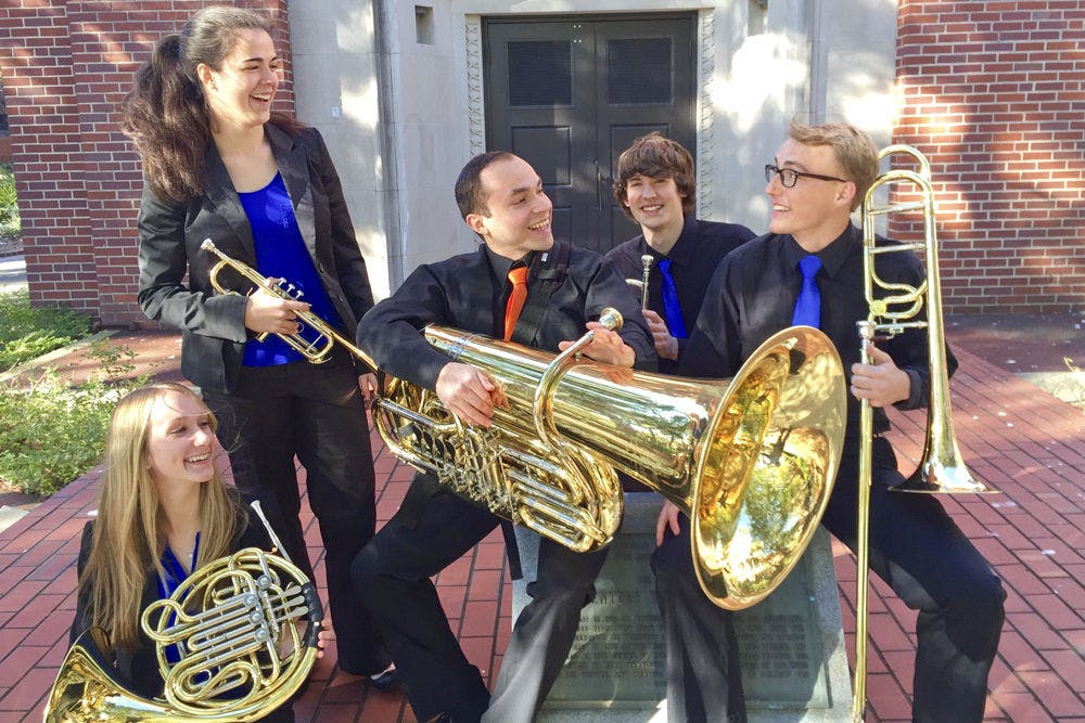 From left: Audrey Bridge, 20, Cara McDermott, 20, Ismael Sandoval, 21, Lucas Owen, 20, and Neal Romberg, 21, pose for a photo outside Century Tower. Together, the five form the Seven Cents Brass Quintet.