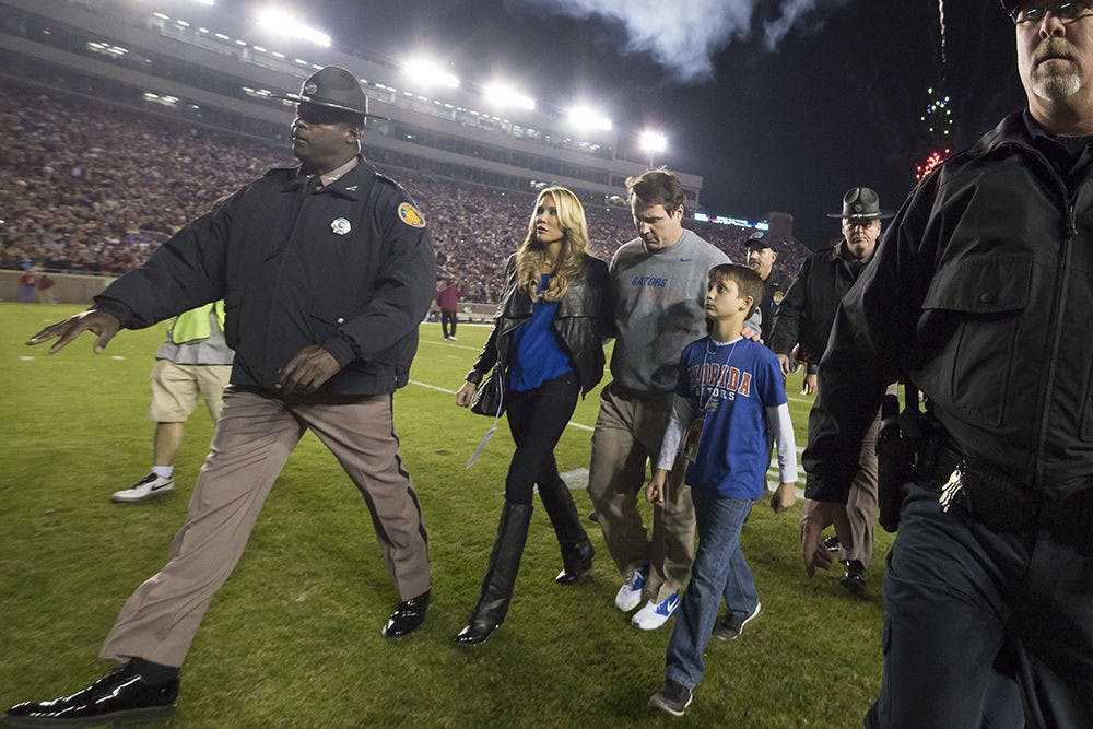 <p>UF coach Will Muschamp walks off the field at Doak Campbell Stadium with his wife and kids following Florida's 24-19 loss to No. 3 Florida State on Saturday in Tallahassee.</p>