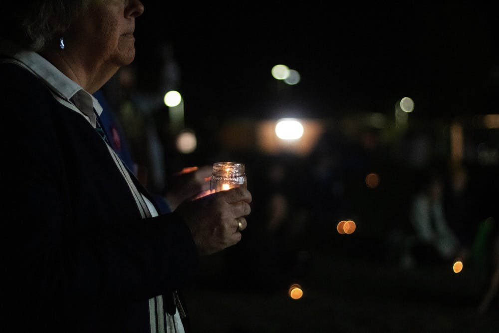 <p dir="ltr">Flo Turcotte holds a candle for the vigil during the Transgender Day of Remembrance at Depot Park Wednesday night.</p>