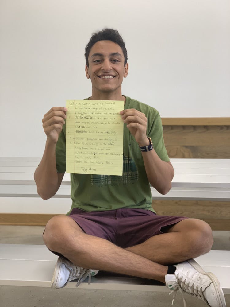 Zakaria Bennouna, a 19-year-old UF mechanical engineering sophomore, holds the lyrics to his viral song “When a Gator Loves his President.” Lyrics include: “Kent Kent Fuchs, you’re the one, daddy Fuchs.”