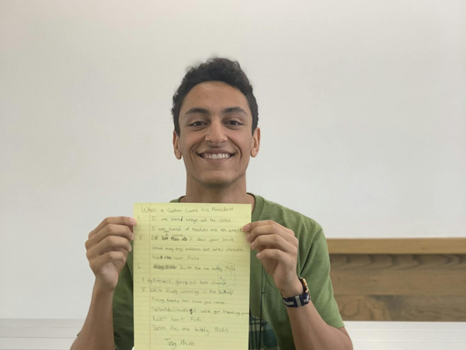 Zakaria Bennouna, a 19-year-old UF mechanical engineering sophomore, holds the lyrics to his viral song “When a Gator Loves his President.” Lyrics include: “Kent Kent Fuchs, you’re the one, daddy Fuchs.”